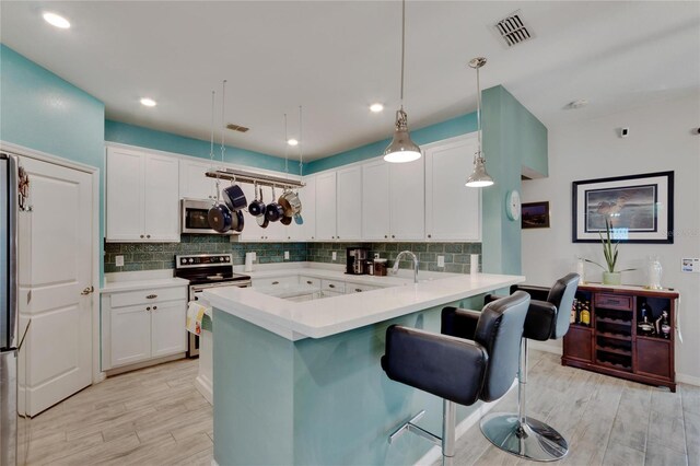 kitchen featuring white cabinets, visible vents, backsplash, and stainless steel appliances