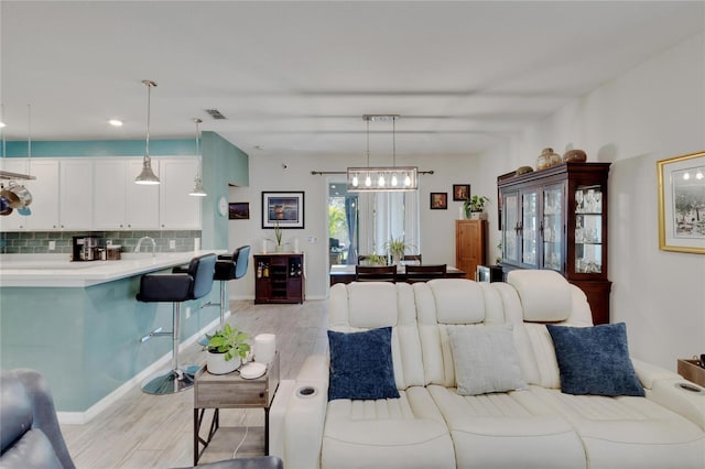 living area featuring light wood-style flooring and visible vents