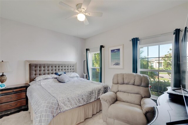 bedroom with a ceiling fan and light carpet