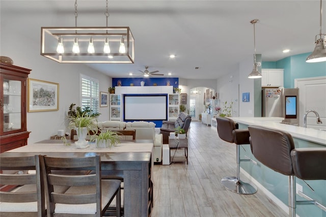 dining area with recessed lighting, arched walkways, a ceiling fan, and light wood finished floors