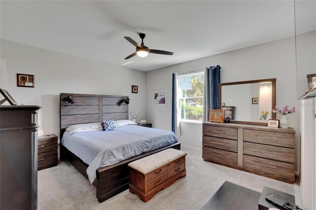 bedroom featuring light colored carpet and a ceiling fan