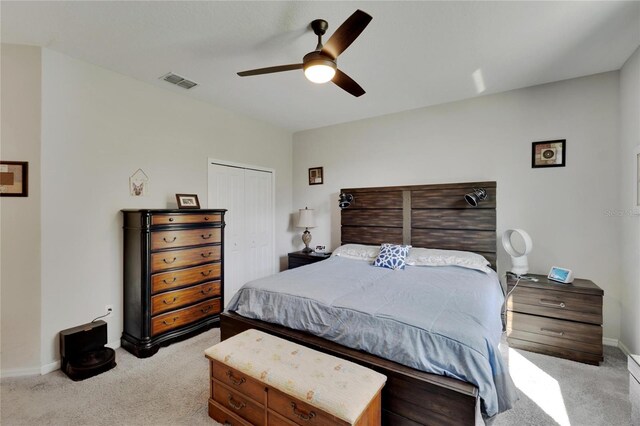 bedroom featuring baseboards, visible vents, a closet, and light carpet