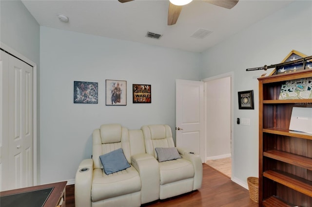 living area with a ceiling fan, dark wood-style floors, visible vents, and baseboards