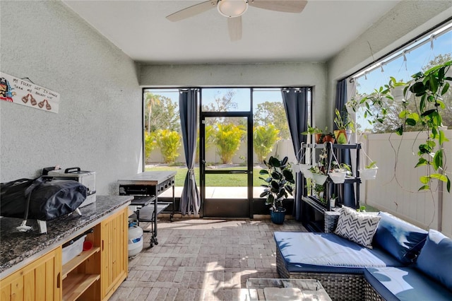 sunroom / solarium featuring a ceiling fan