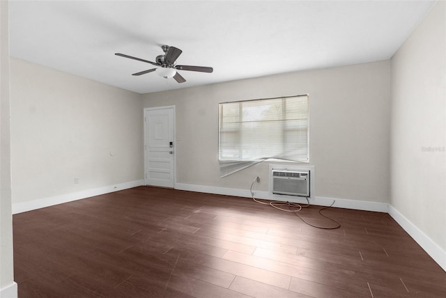 spare room with baseboards, a wall unit AC, and wood finished floors