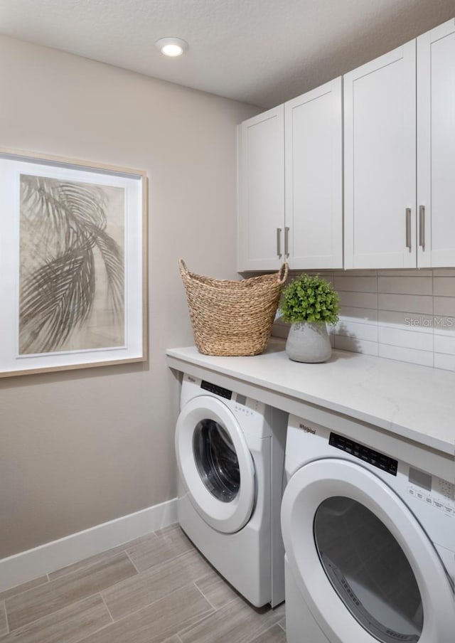 17420 Moonflower Dr Unit 101, Venice, FL 34293 - laundry area featuring washing machine and clothes dryer, baseboards, recessed lighting, wood tiled floor, and cabinet space