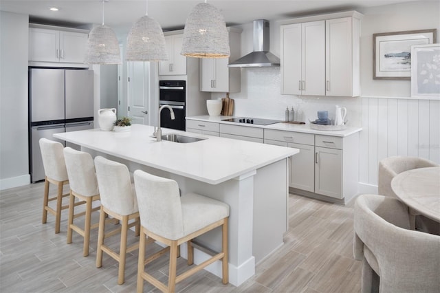 17420 Moonflower Dr Unit 101, Venice, FL 34293 - kitchen featuring wall chimney exhaust hood, a sink, black electric stovetop, double oven, and freestanding refrigerator