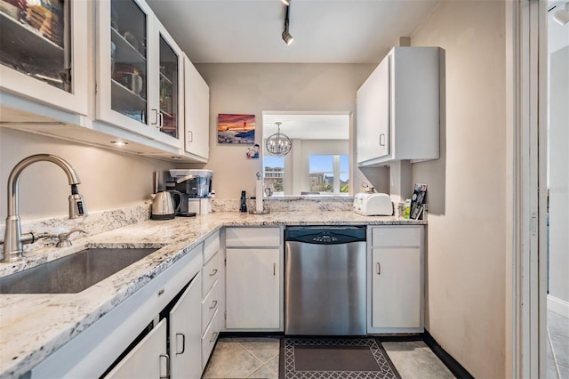 kitchen featuring light stone counters, white cabinetry, a sink, glass insert cabinets, and stainless steel dishwasher