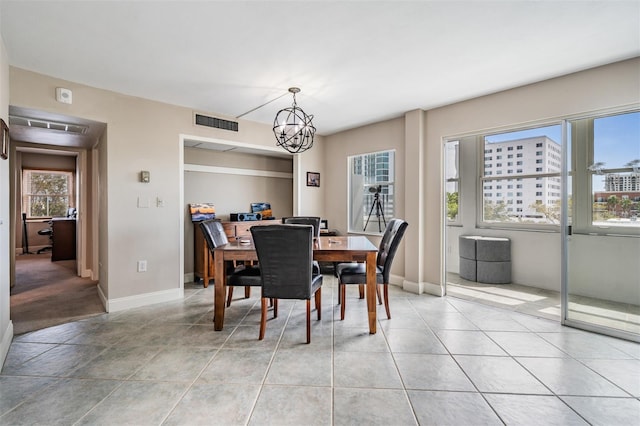dining area with light tile patterned floors, visible vents, baseboards, and a chandelier