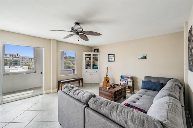 living room featuring light tile patterned floors, baseboards, a wealth of natural light, and ceiling fan