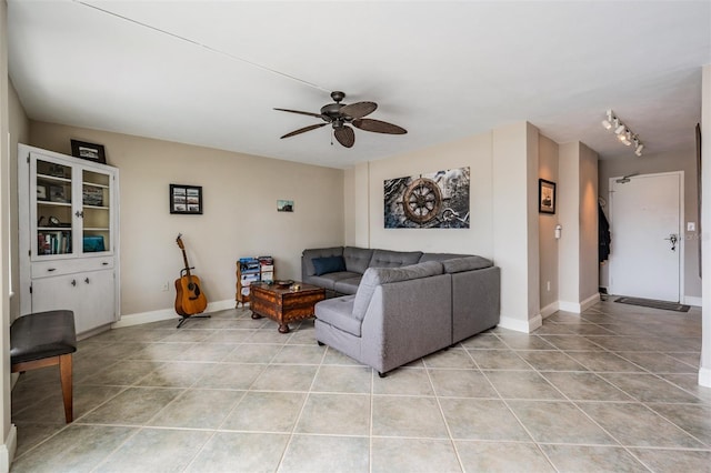 living room with light tile patterned flooring, baseboards, and ceiling fan