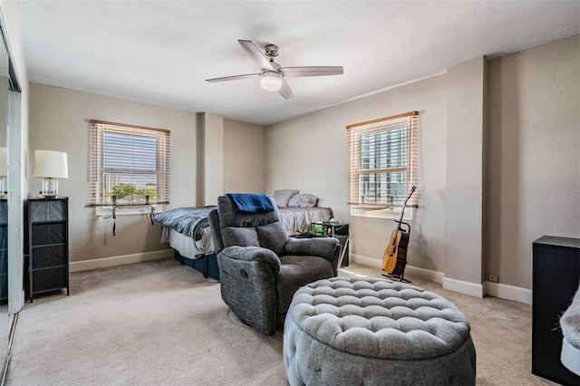 bedroom featuring a ceiling fan, light colored carpet, and baseboards