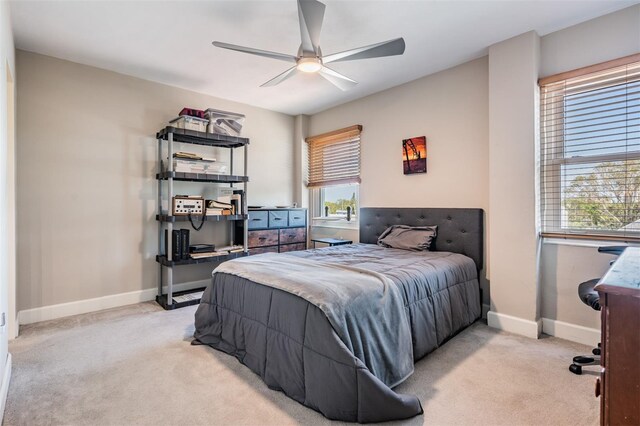 bedroom with baseboards, light colored carpet, and a ceiling fan
