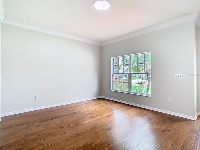 empty room featuring ornamental molding, baseboards, and dark wood-style flooring