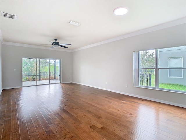 unfurnished room featuring visible vents, baseboards, dark wood-style flooring, and crown molding