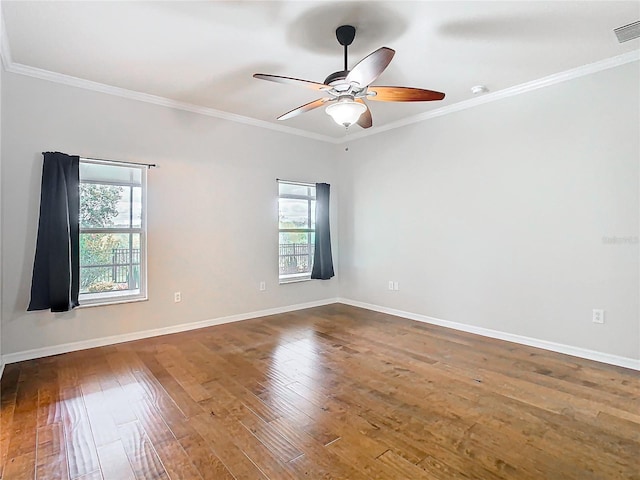 empty room with a ceiling fan, crown molding, baseboards, and hardwood / wood-style flooring