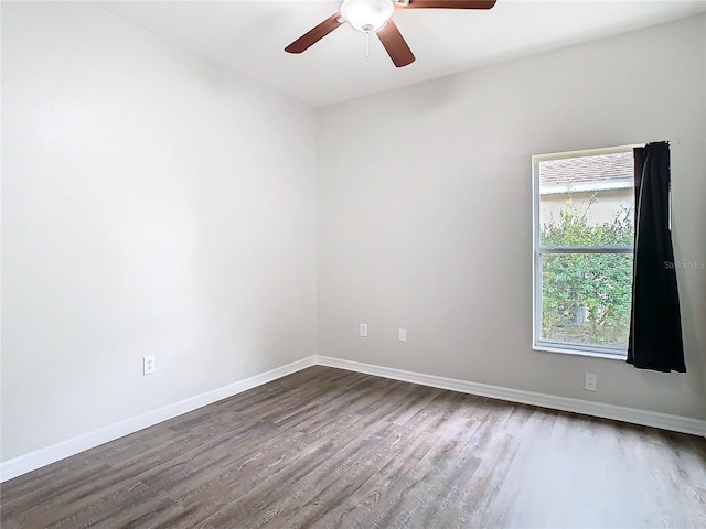 empty room featuring a ceiling fan, wood finished floors, and baseboards