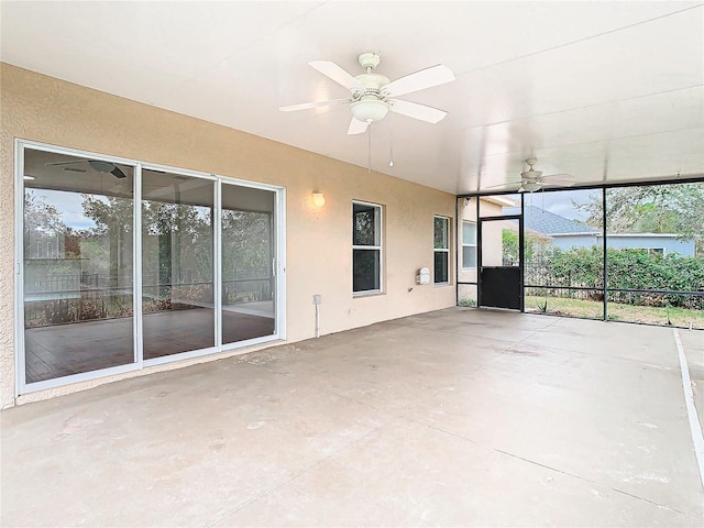 unfurnished sunroom featuring ceiling fan