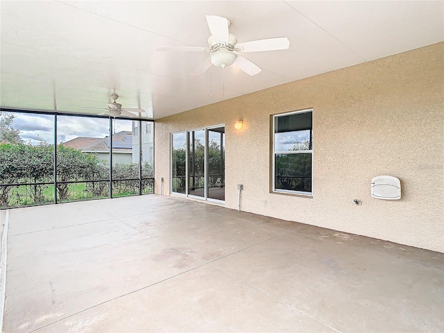 unfurnished sunroom featuring ceiling fan