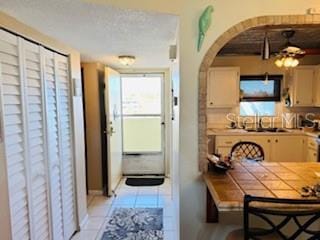 interior space featuring light tile patterned flooring and arched walkways