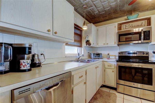 kitchen featuring a sink, light countertops, an ornate ceiling, and stainless steel appliances