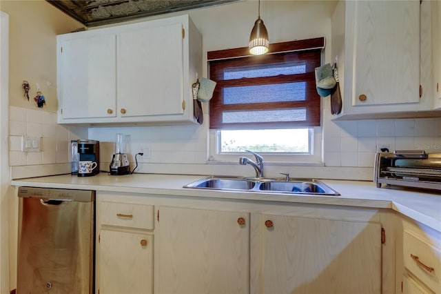 kitchen with dishwasher, light countertops, backsplash, and a sink