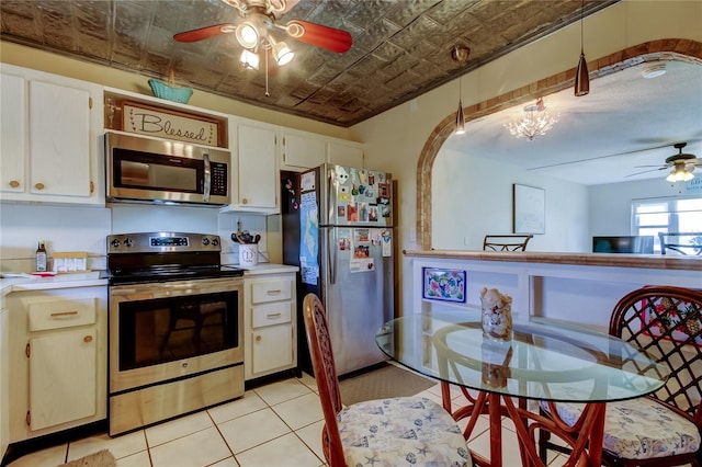 kitchen with appliances with stainless steel finishes, an ornate ceiling, light countertops, and a ceiling fan