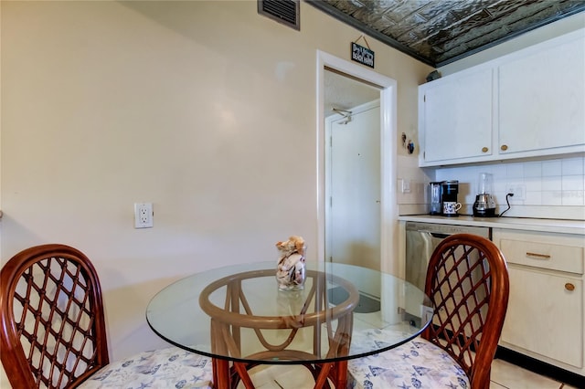 dining space with light tile patterned flooring, visible vents, and an ornate ceiling