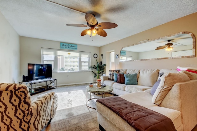 living area with baseboards, carpet, a ceiling fan, and a textured ceiling