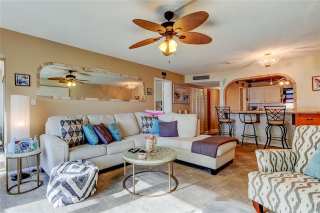 living area featuring visible vents, arched walkways, and ceiling fan