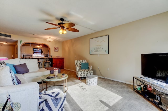 living room with visible vents, arched walkways, baseboards, and a ceiling fan