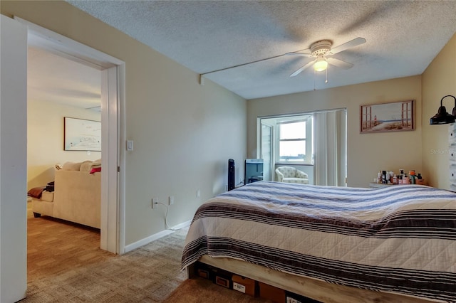 bedroom featuring light colored carpet, a textured ceiling, baseboards, and a ceiling fan