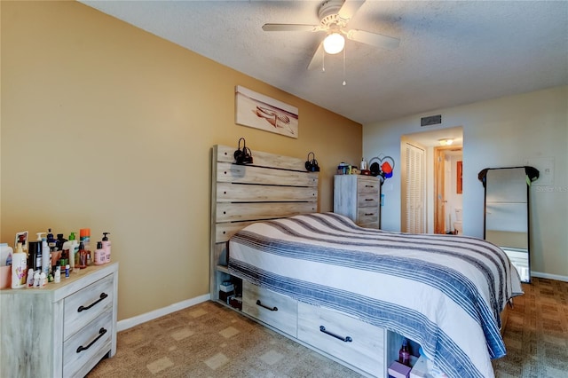 bedroom with visible vents, a textured ceiling, carpet, baseboards, and ceiling fan