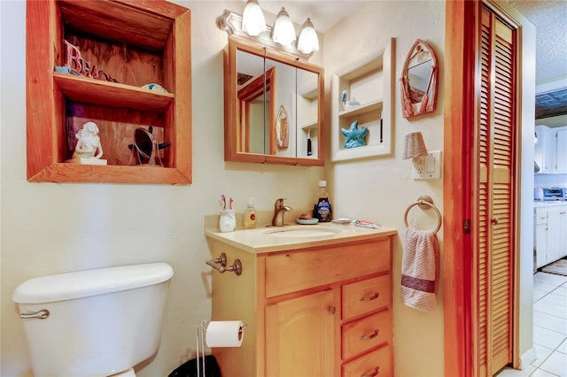 bathroom featuring vanity, tile patterned floors, and toilet