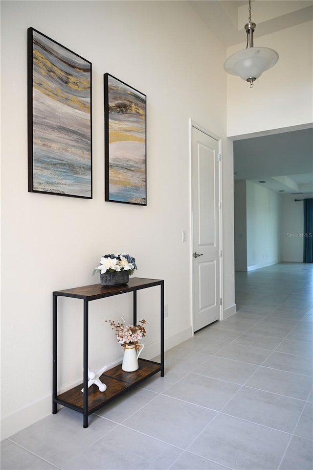 corridor with tile patterned flooring and baseboards