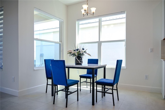 dining area with a notable chandelier, baseboards, and light tile patterned floors