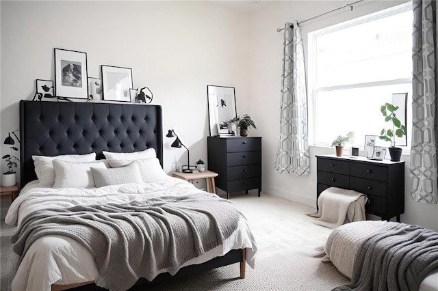 bedroom featuring light colored carpet and baseboards