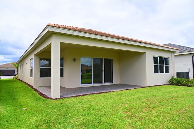 back of property with a patio area, stucco siding, and a lawn