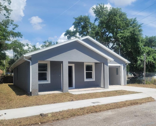 3312 Lila St, Tampa, FL 33610 - view of front of house featuring concrete driveway, stucco siding, and a porch