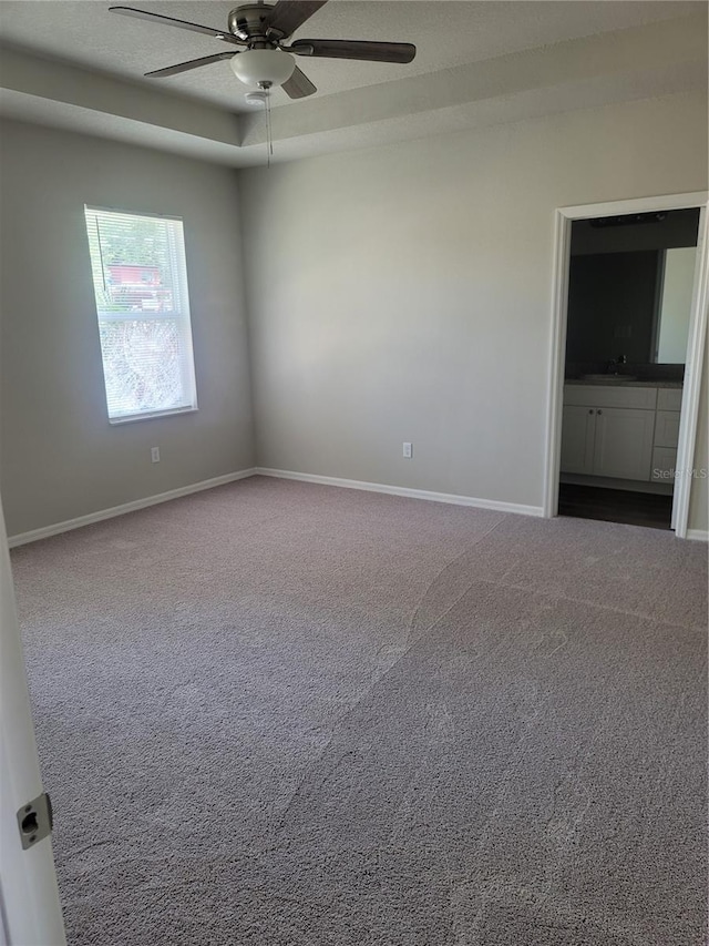 3312 Lila St, Tampa, FL 33610 - empty room featuring carpet flooring, baseboards, a raised ceiling, and ceiling fan