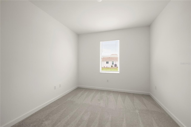 empty room with light colored carpet and baseboards