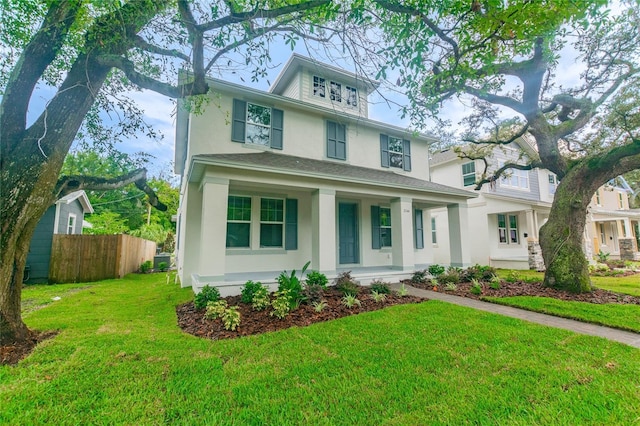 324 37th Ave NE, Saint Petersburg, FL 33704 - american foursquare style home featuring a porch, stucco siding, a front yard, and fence