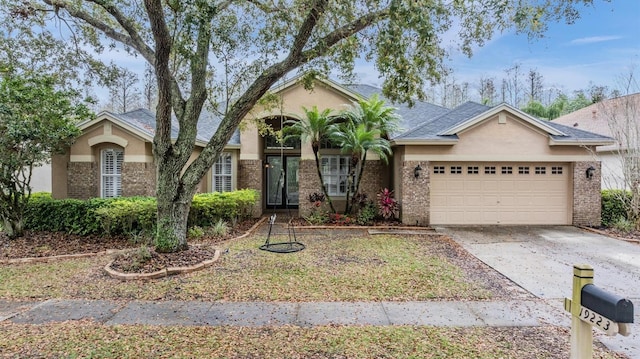 ranch-style home featuring brick siding, stucco siding, driveway, and an attached garage