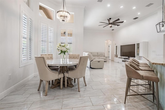 dining space featuring ceiling fan with notable chandelier, crown molding, visible vents, and arched walkways