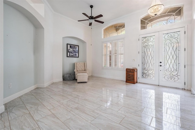 unfurnished room featuring french doors, arched walkways, baseboards, and ornamental molding