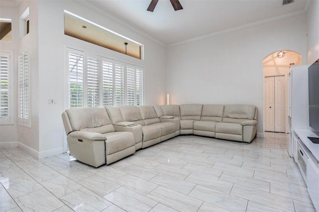 unfurnished living room featuring a ceiling fan, visible vents, baseboards, arched walkways, and ornamental molding