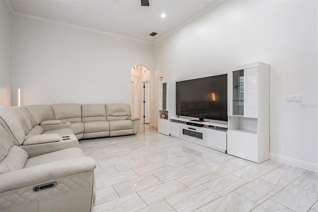 living room with arched walkways, visible vents, baseboards, and ornamental molding