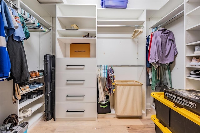 walk in closet with wood finished floors