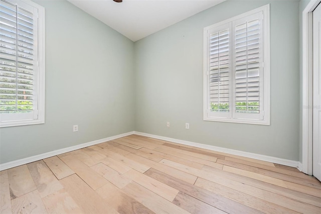 unfurnished room with wood finished floors, baseboards, and a wealth of natural light