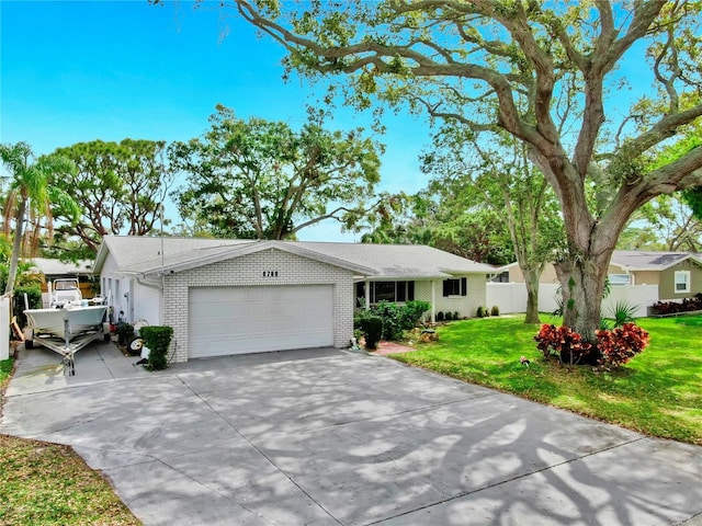 ranch-style house featuring brick siding, a front lawn, fence, concrete driveway, and an attached garage